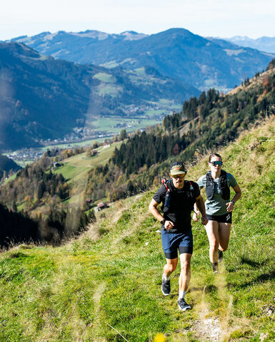Ein weißer Flurbereich mit einer offenen Garderobe, Kissen und einem kleinen schwarzen Schild