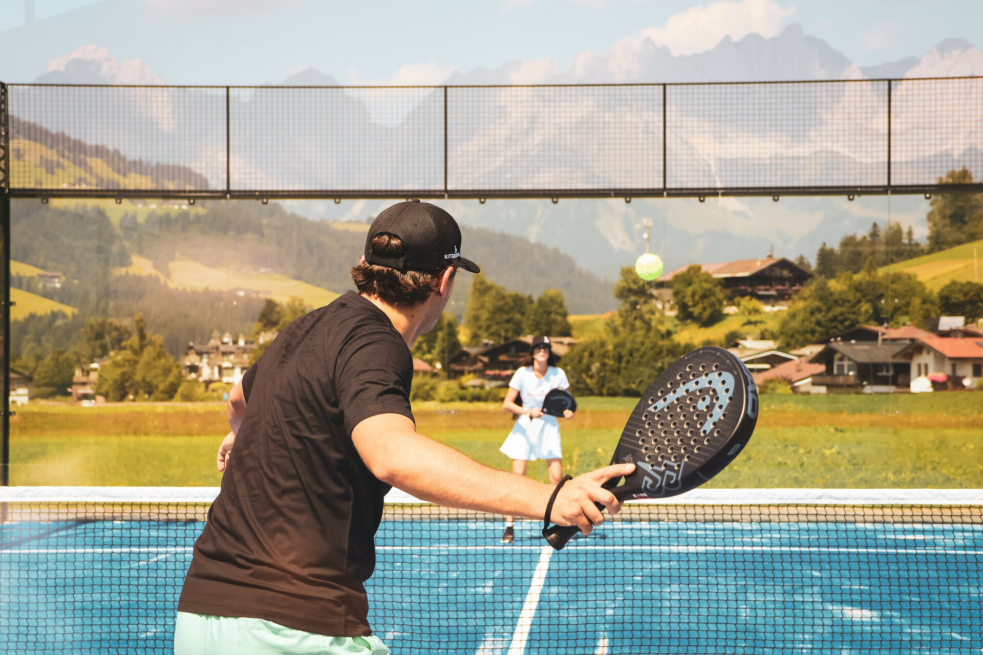 Zwei Menschen spielen Padel Tennis vor beeindruckender Kulisse