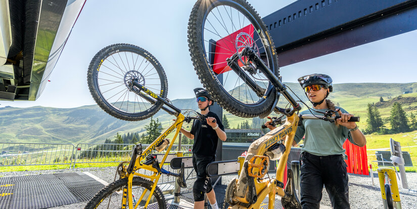 Biker fahren mit einer Gondel in Kitzbühel auf den Berg