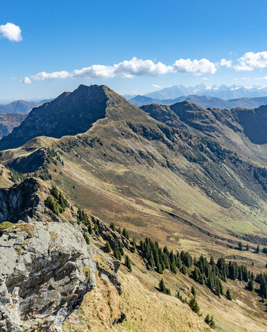 Ein weißer Flurbereich mit einer offenen Garderobe, Kissen und einem kleinen schwarzen Schild