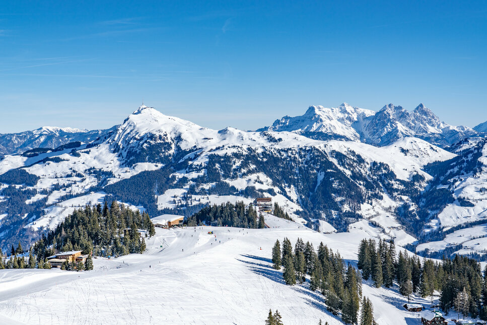 Hahnenkamm, Skigebiet Kitzbühel, verschneite Berglandschaft unter klarem, blauem Himmel.
