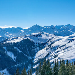 Jochberg, Skigebiet Kitzbühel, verschneite Berglandschaft unter klarem, blauem Himmel.