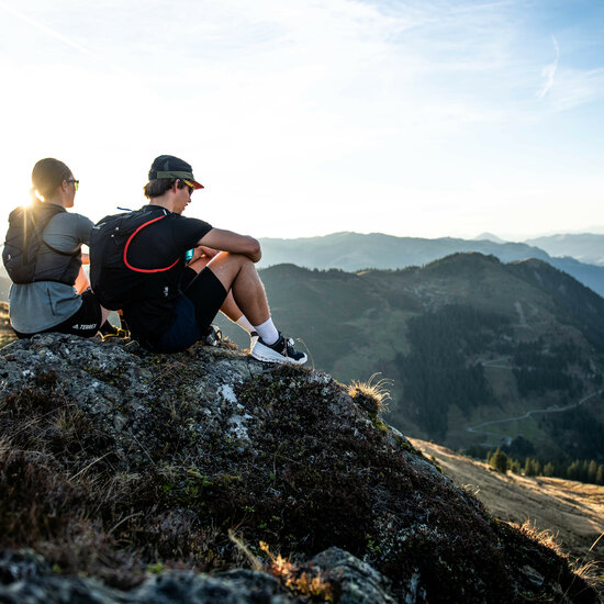 Ein weißer Flurbereich mit einer offenen Garderobe, Kissen und einem kleinen schwarzen Schild