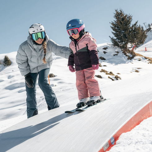 Mutter übt mit ihrem Kind Skifahren in Kitzbühel