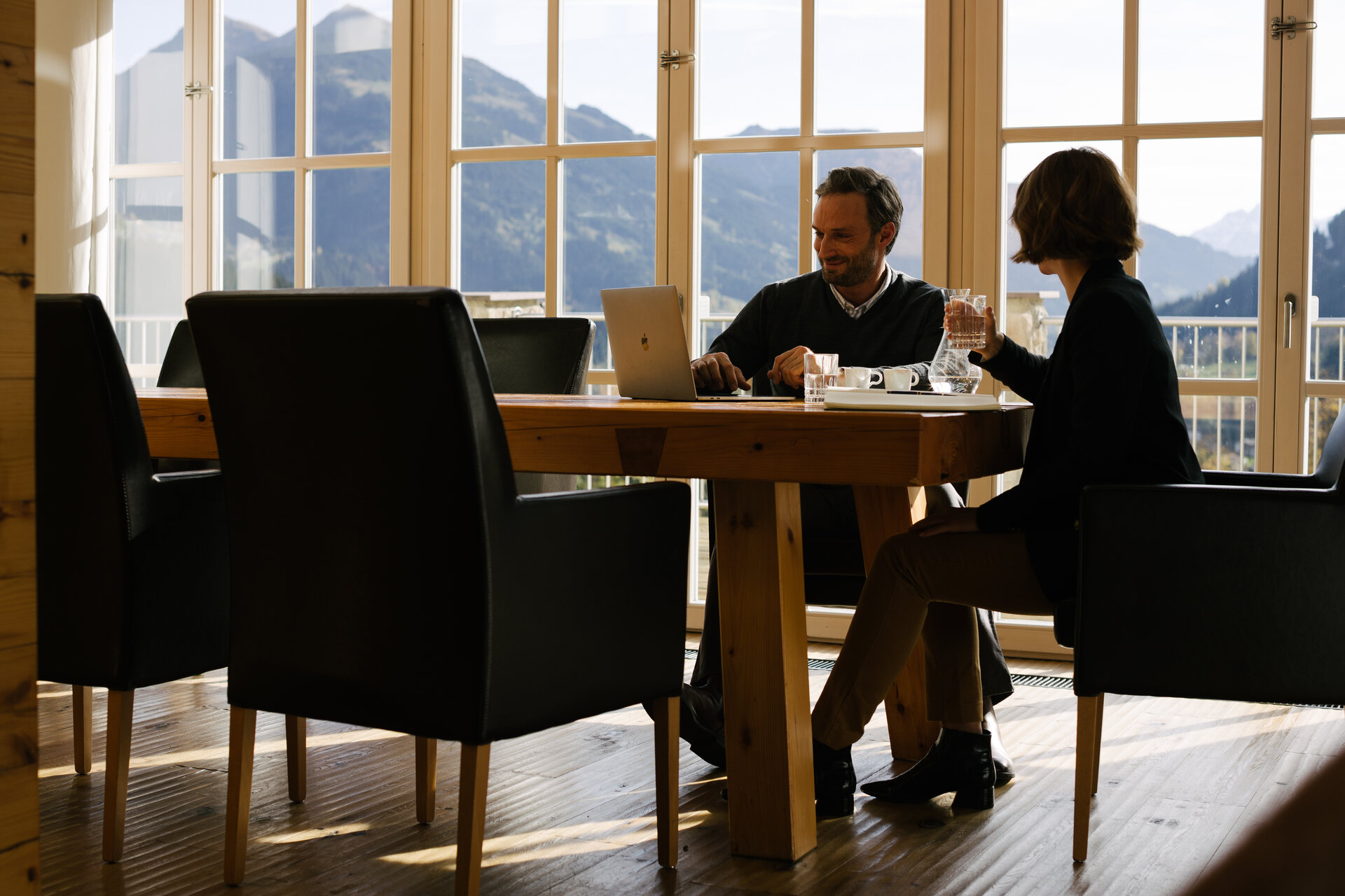 Besprechung am Tisch mit Ausblick in die Natur
