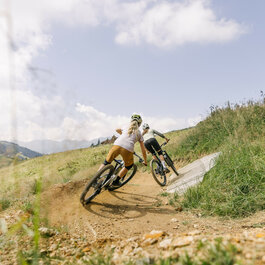 Ein weißer Flurbereich mit einer offenen Garderobe, Kissen und einem kleinen schwarzen Schild