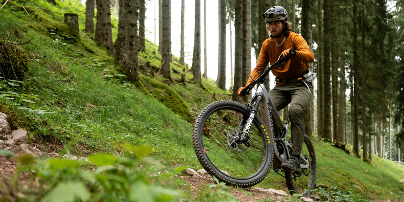 Ein weißer Flurbereich mit einer offenen Garderobe, Kissen und einem kleinen schwarzen Schild