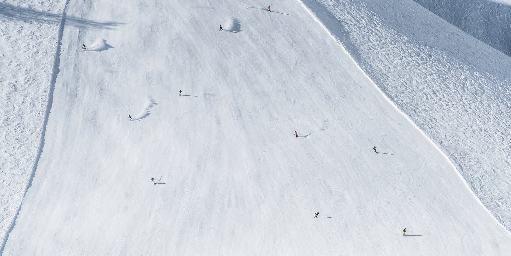Mehrere Skifahrer fahren auf einer Piste in Kitzbühel