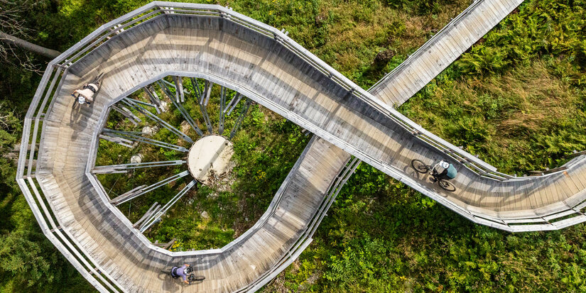 Ein weißer Flurbereich mit einer offenen Garderobe, Kissen und einem kleinen schwarzen Schild