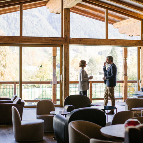 Ein weißer Flurbereich mit einer offenen Garderobe, Kissen und einem kleinen schwarzen Schild