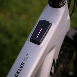 Ein weißer Flurbereich mit einer offenen Garderobe, Kissen und einem kleinen schwarzen Schild