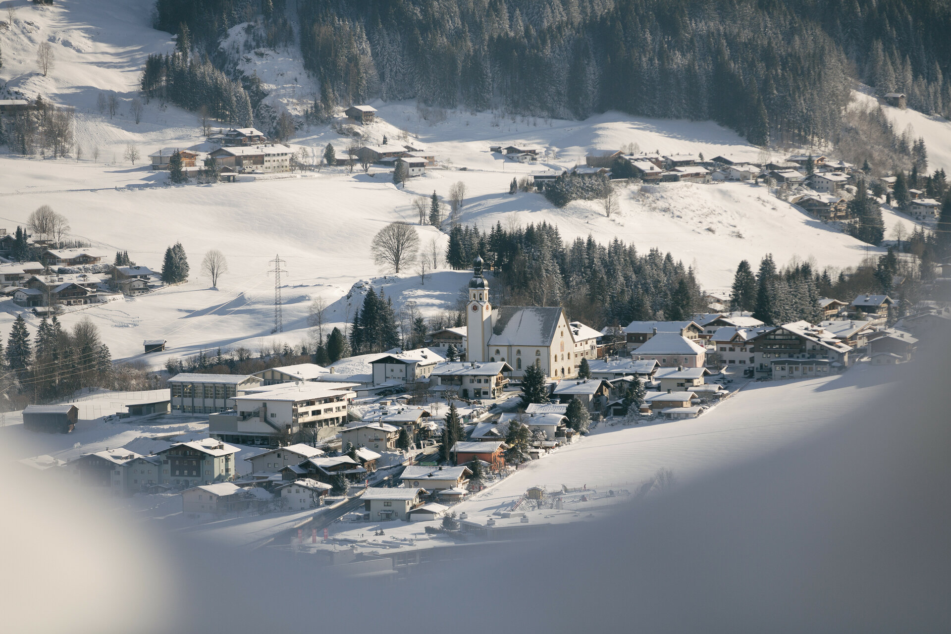 Ein weißer Flurbereich mit einer offenen Garderobe, Kissen und einem kleinen schwarzen Schild