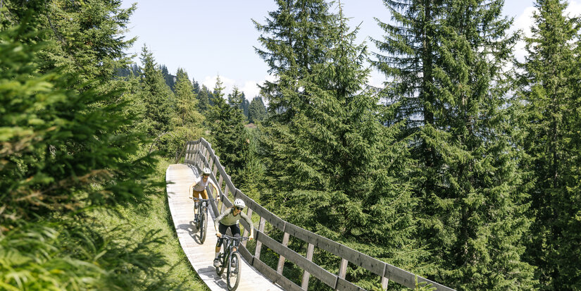 Ein weißer Flurbereich mit einer offenen Garderobe, Kissen und einem kleinen schwarzen Schild