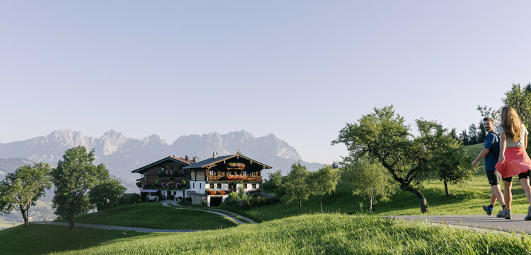 Ein weißer Flurbereich mit einer offenen Garderobe, Kissen und einem kleinen schwarzen Schild
