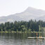 Eine Familie genießt einen sonnigen Tag auf einer schwimmenden Insel am Schwarzsee in Kitzbühel und bewundert die Natur mit dem Kitzbüheler Horn im Hintergrund.