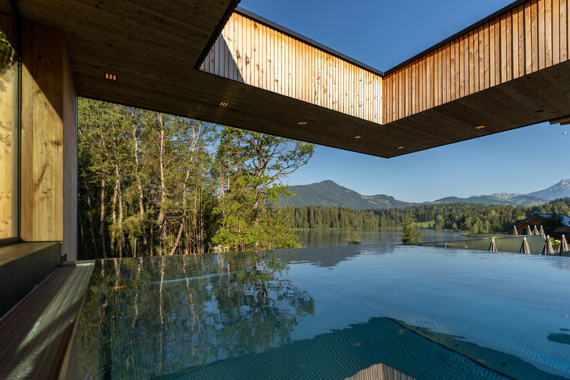 Ein weißer Flurbereich mit einer offenen Garderobe, Kissen und einem kleinen schwarzen Schild