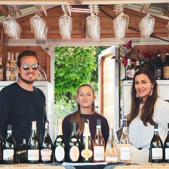 Ein weißer Flurbereich mit einer offenen Garderobe, Kissen und einem kleinen schwarzen Schild