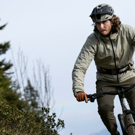 Ein weißer Flurbereich mit einer offenen Garderobe, Kissen und einem kleinen schwarzen Schild