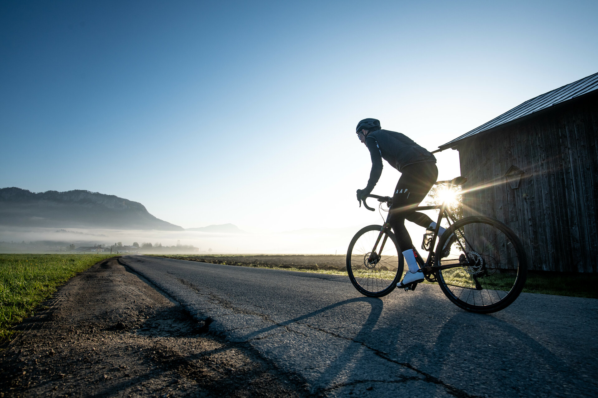 Ein weißer Flurbereich mit einer offenen Garderobe, Kissen und einem kleinen schwarzen Schild