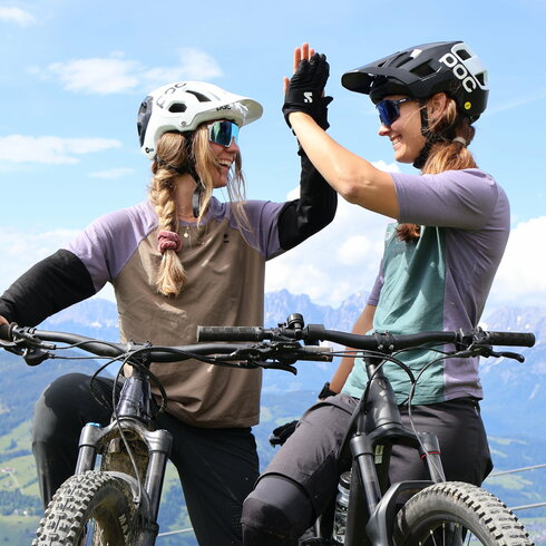 Ein weißer Flurbereich mit einer offenen Garderobe, Kissen und einem kleinen schwarzen Schild