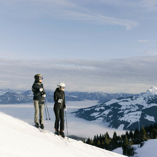 Zwei Skifahrer stehen auf einer Piste in Kitzbühel