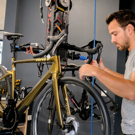 Ein weißer Flurbereich mit einer offenen Garderobe, Kissen und einem kleinen schwarzen Schild