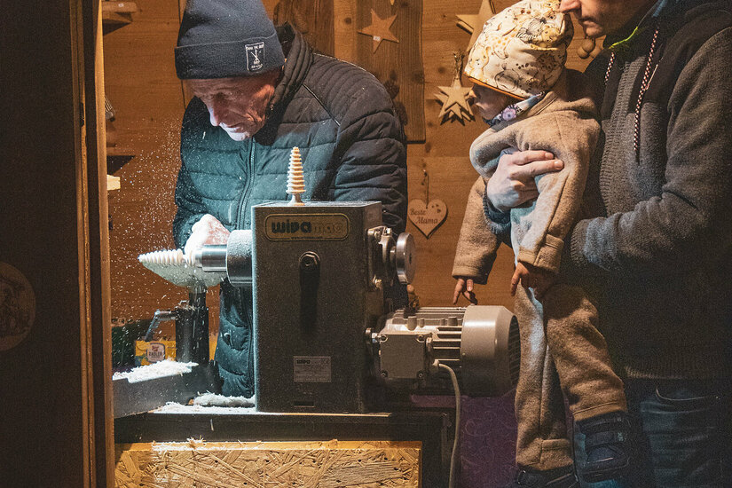 Ein weißer Flurbereich mit einer offenen Garderobe, Kissen und einem kleinen schwarzen Schild