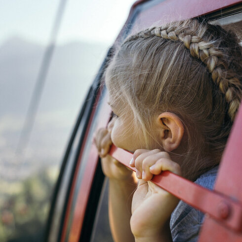 Mädchen schaut aus der Gondel auf Kitzbühel hinunter