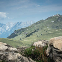 Ein weißer Flurbereich mit einer offenen Garderobe, Kissen und einem kleinen schwarzen Schild