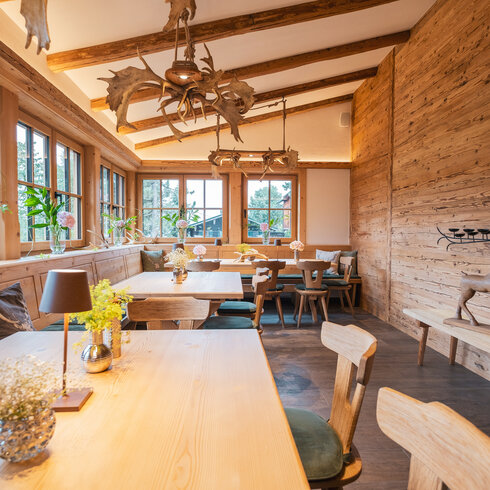 Ein weißer Flurbereich mit einer offenen Garderobe, Kissen und einem kleinen schwarzen Schild