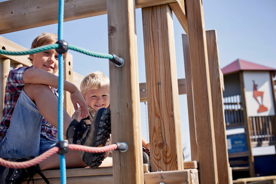Kinder spielen vergnügt auf einem Spielplatz in Kitzbühel