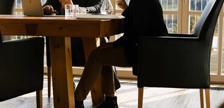 Besprechung am Tisch mit Ausblick in die Natur