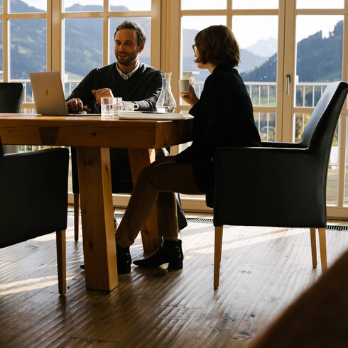 Besprechung am Tisch mit Ausblick in die Natur