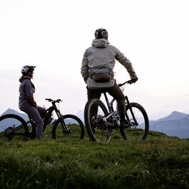 Ein weißer Flurbereich mit einer offenen Garderobe, Kissen und einem kleinen schwarzen Schild