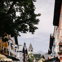 Ein weißer Flurbereich mit einer offenen Garderobe, Kissen und einem kleinen schwarzen Schild