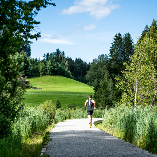 Ein weißer Flurbereich mit einer offenen Garderobe, Kissen und einem kleinen schwarzen Schild