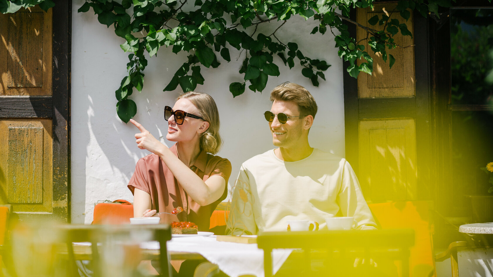 Paar sitzt auf einer Bank vor einem Haus in Kitzbühel