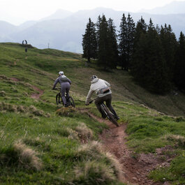 Ein weißer Flurbereich mit einer offenen Garderobe, Kissen und einem kleinen schwarzen Schild