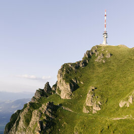 Ein weißer Flurbereich mit einer offenen Garderobe, Kissen und einem kleinen schwarzen Schild