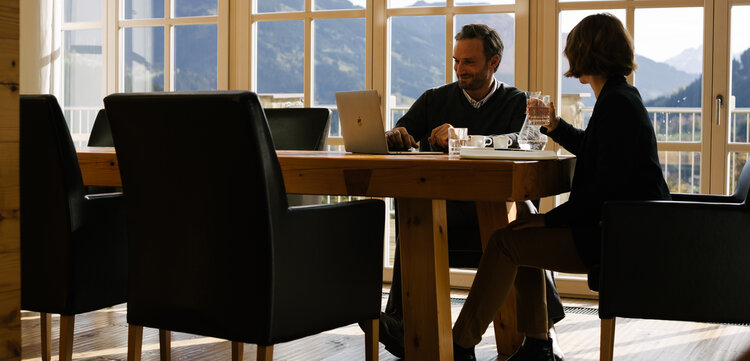 Besprechung am Tisch mit Ausblick in die Natur