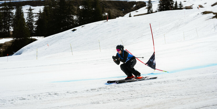 Skimovie Strecke, Skigebiet Kitzbühel, Skifahrer im Riesentorlauf zwischen Toren auf der Piste.
