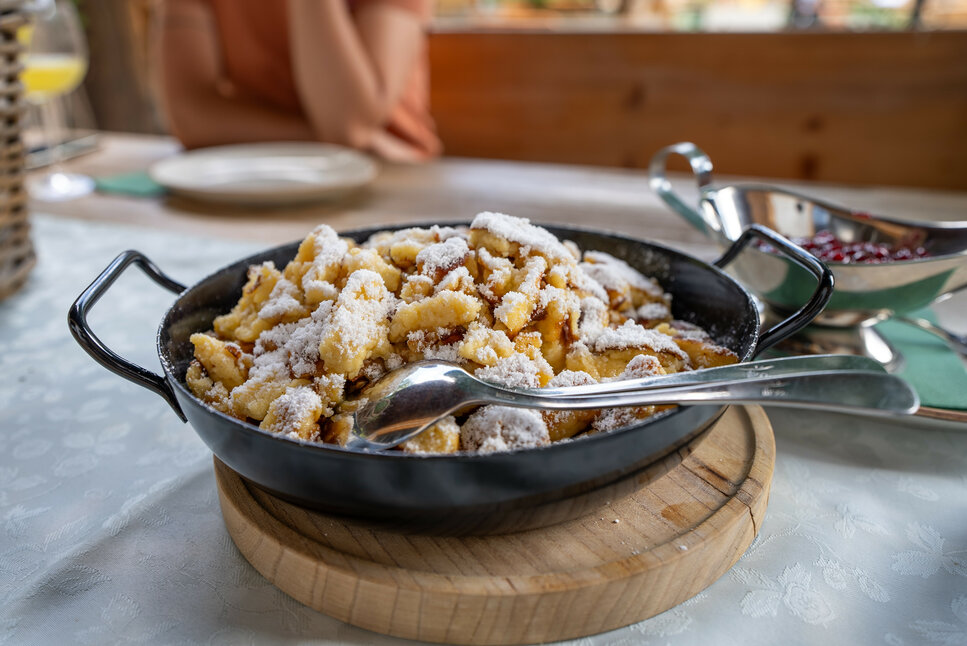 Ein weißer Flurbereich mit einer offenen Garderobe, Kissen und einem kleinen schwarzen Schild