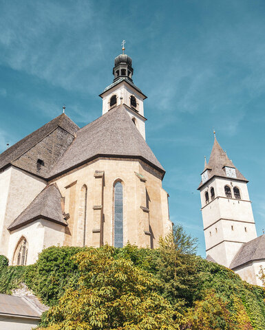 Die historische Kirche zeigt ihre markanten Türme und gotischen Fenster, eingebettet in eine malerische Landschaft.