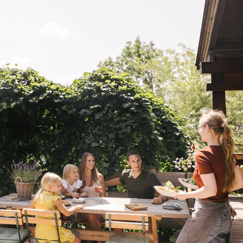 Familie sitzt bei herrlichem Wetter in einem Restaurant in Kitzbühel