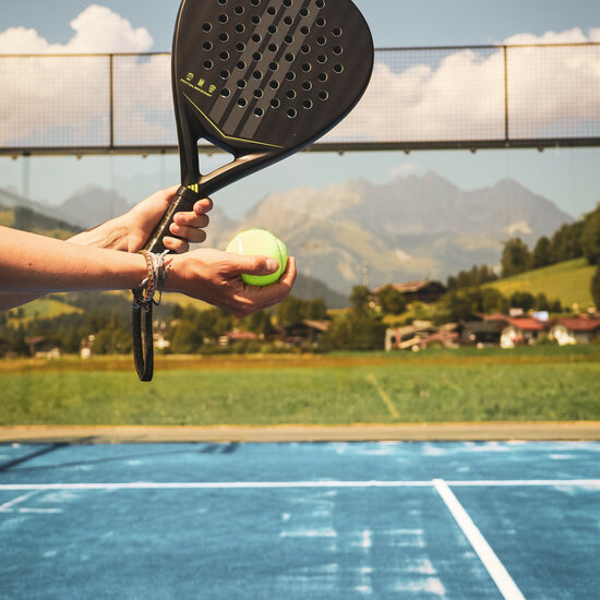 Ein weißer Flurbereich mit einer offenen Garderobe, Kissen und einem kleinen schwarzen Schild