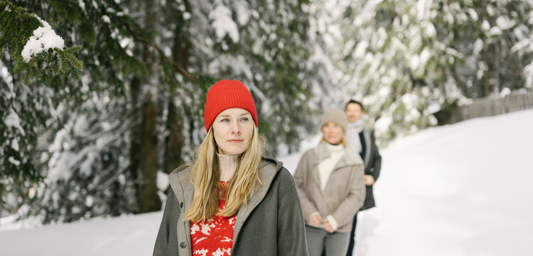 Ein weißer Flurbereich mit einer offenen Garderobe, Kissen und einem kleinen schwarzen Schild