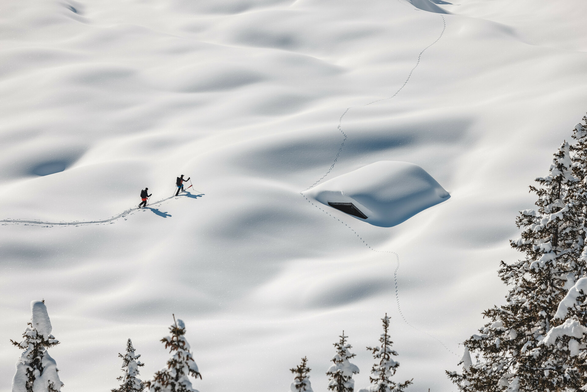 Ein weißer Flurbereich mit einer offenen Garderobe, Kissen und einem kleinen schwarzen Schild