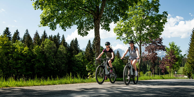 Ein weißer Flurbereich mit einer offenen Garderobe, Kissen und einem kleinen schwarzen Schild