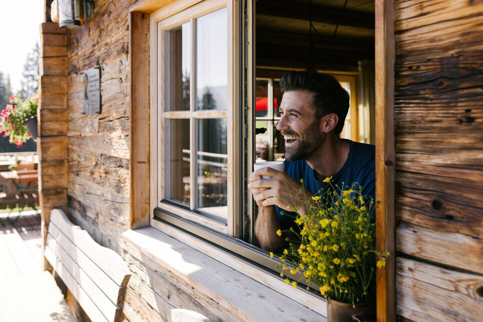 Ein weißer Flurbereich mit einer offenen Garderobe, Kissen und einem kleinen schwarzen Schild