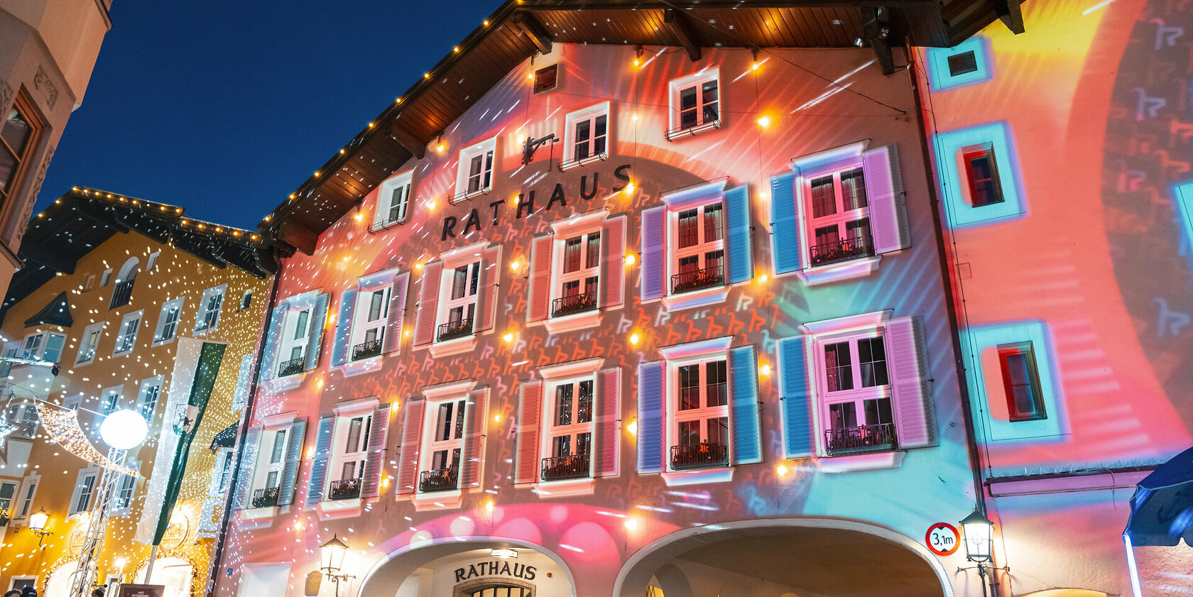 Ein weißer Flurbereich mit einer offenen Garderobe, Kissen und einem kleinen schwarzen Schild